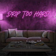 hot pink drip too hard neon sign hanging on living room wall