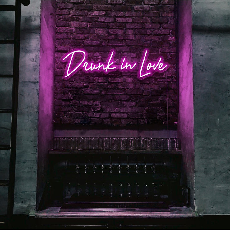 hot pink drunk in love neon sign hanging on bar wall