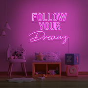 hot pink follow your dreams neon sign hanging on kids bedroom wall