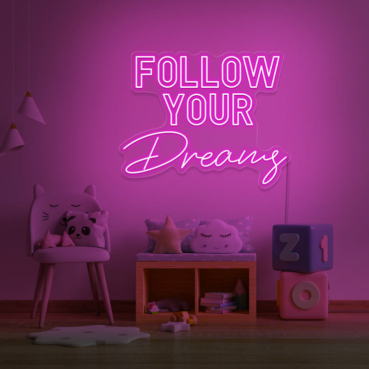 hot pink follow your dreams neon sign hanging on kids bedroom wall