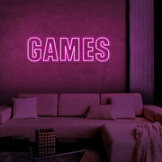 hot pink games neon sign hanging on games room wall