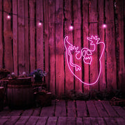 hot pink ghost neon sign hanging on timber wall