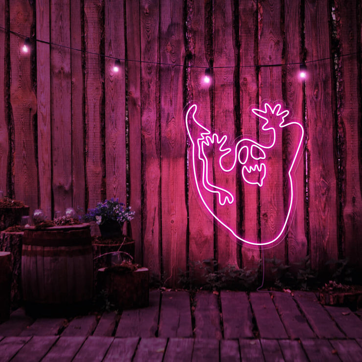 hot pink ghost neon sign hanging on timber wall