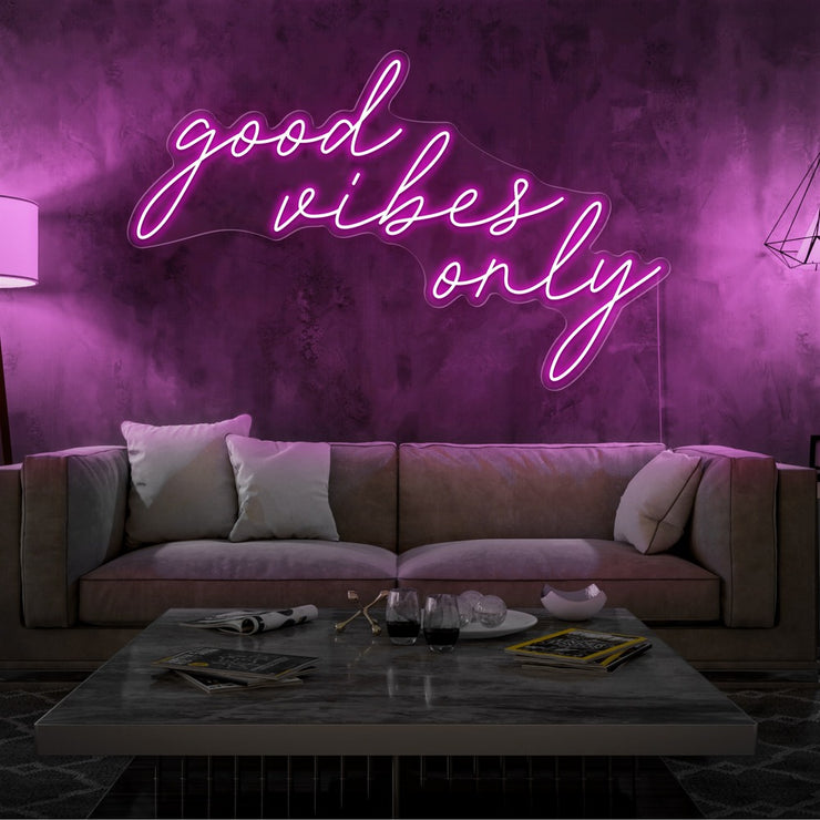 hot pink good vibes only neon sign hanging on living room wall