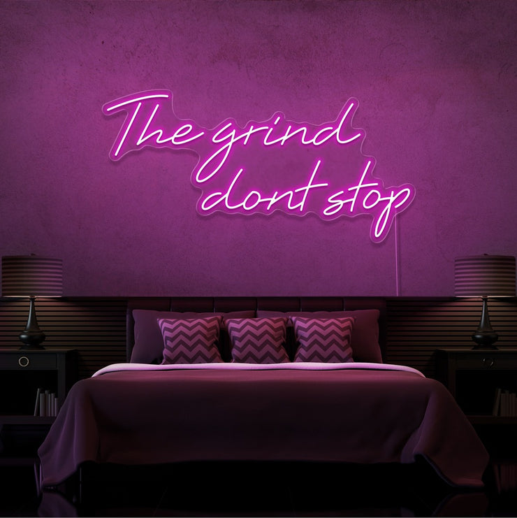 hot pink the grind dont stop neon sign hanging on bedroom wall