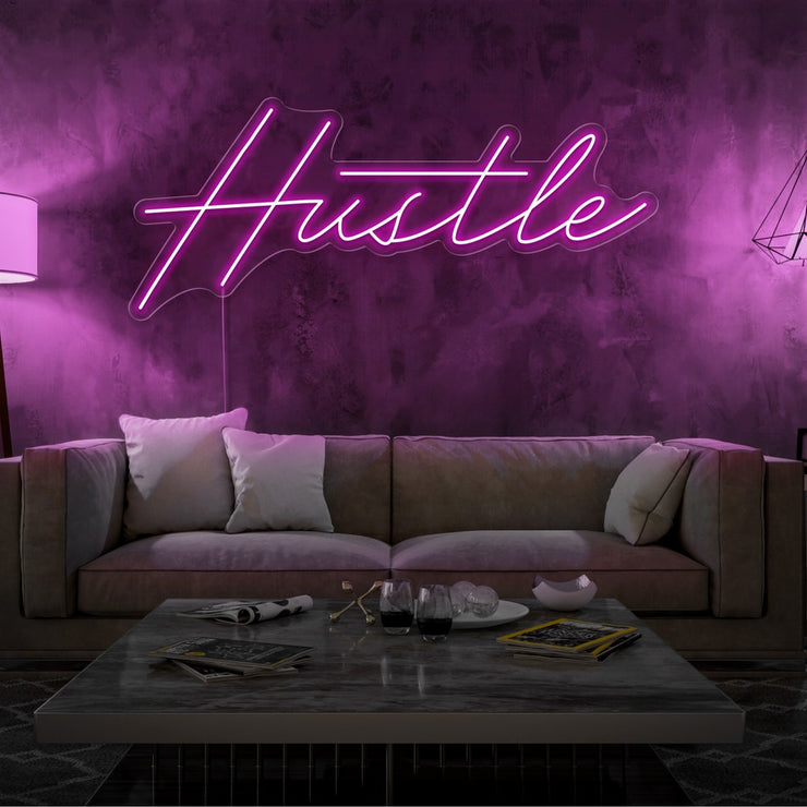 hot pink hustle neon sign hanging on living room wall