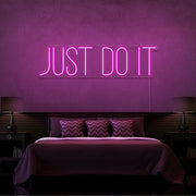 hot pink just do it neon sign hanging on bedroom wall