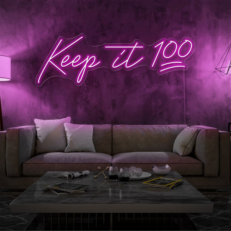 hot pink keep it 100 neon sign hanging on living room wall