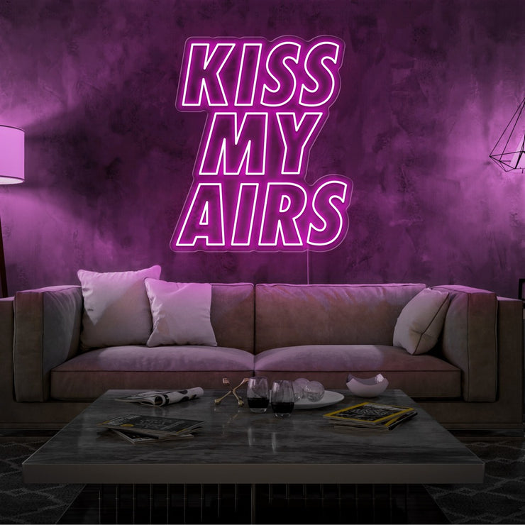 hot pink kiss my airs neon sign hanging on living room wall