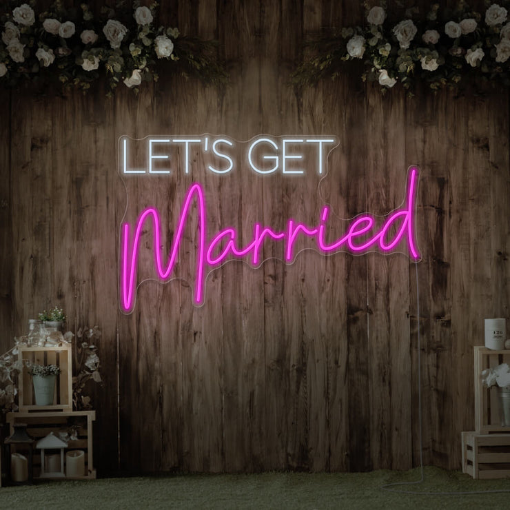 hot pink lets get married neon sign hanging on timber wall