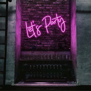 hot pink lets party neon sign hanging on bar wall