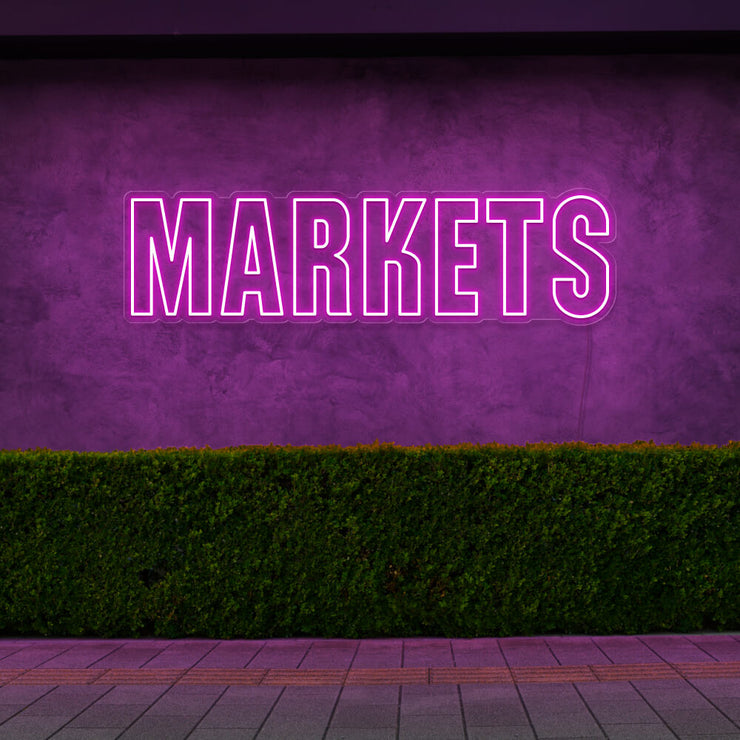 hot pink markets neon sign hanging on outside wall