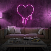hot pink melting heart neon sign hanging on living room wall
