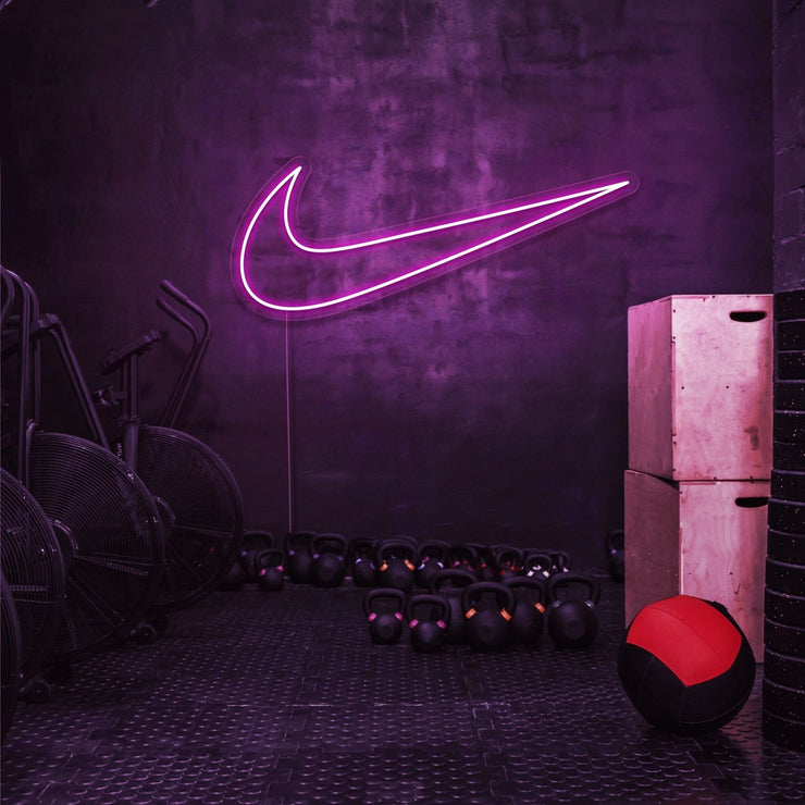 hot pink nike swoosh neon sign hanging on gym wall