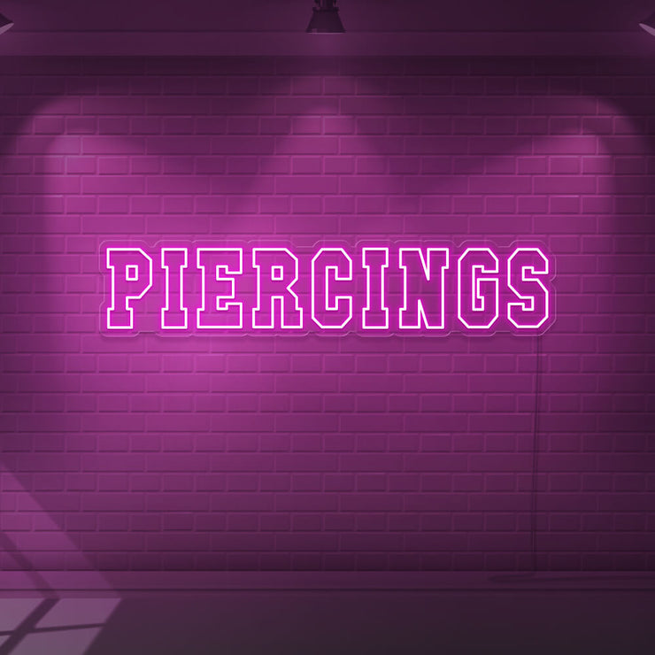 hot pink piercings neon sign hanging on wall
