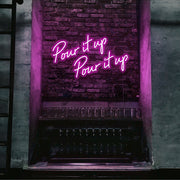 hot pink pour it up neon sign hanging on bar wall