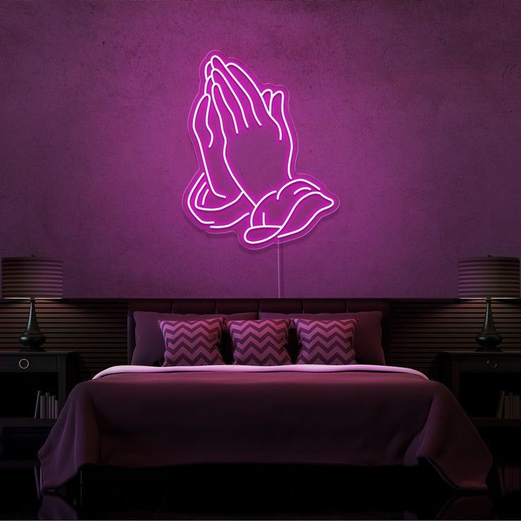 hot pink praying hands neon sign hanging on bedroom wall