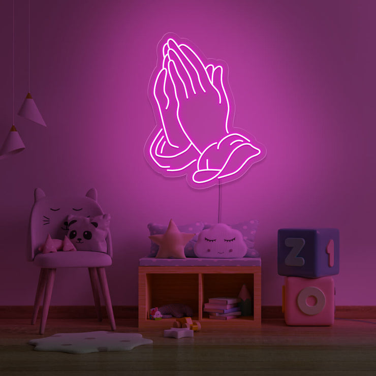 hot pink praying hands neon sign hanging on kids bedroom wall