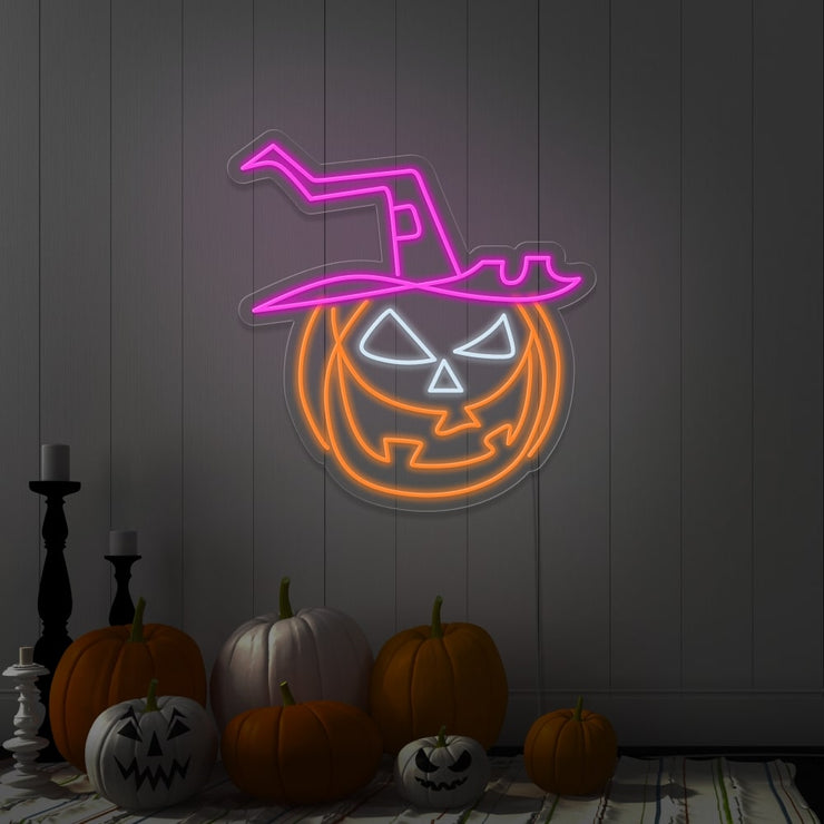 hot pink pumpkin hat neon sign hanging on wall next to pumpkins