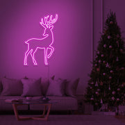 hot pink reindeer neon sign hanging on living room wall next to christmas tree