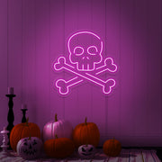 hot pink skull bones neon sign with pumpkins on floor