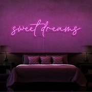 hot pink sweet dreams neon sign hanging on bedroom wall
