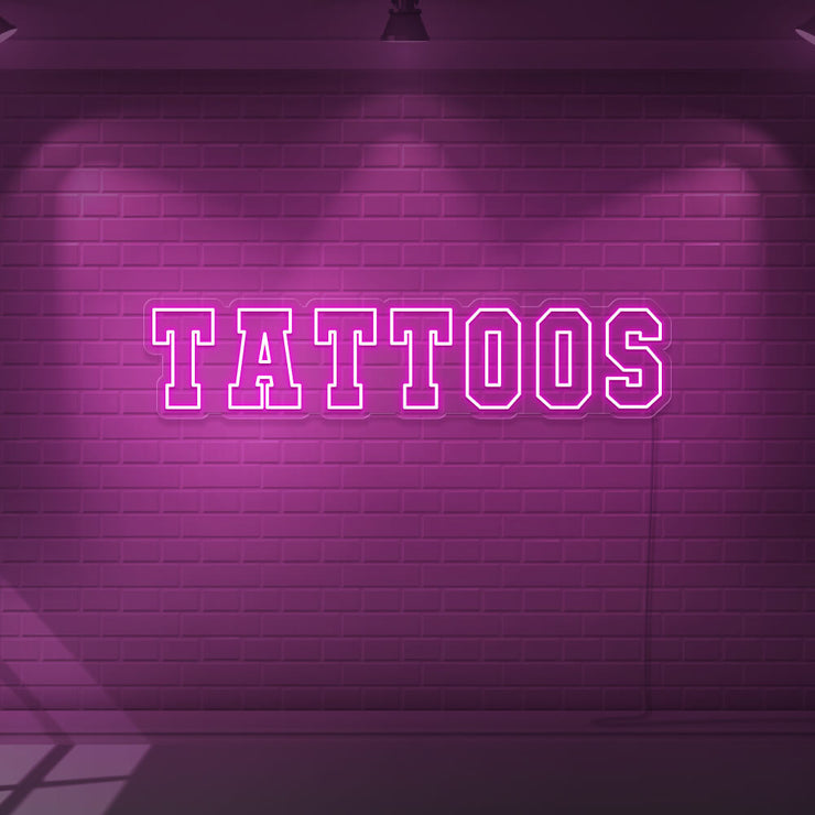 hot pink tattoos neon sign hanging on wall