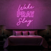 hot pink wake pray slay neon sign hanging on bedroom wall