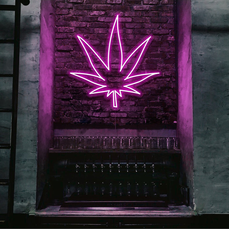 hot pink weed leaf neon sign hanging on bar wall