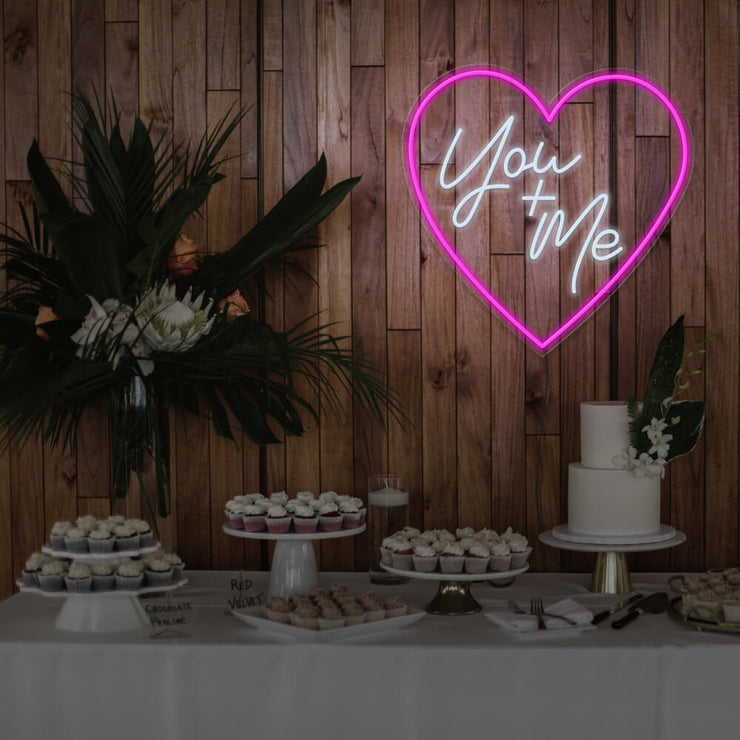 hot pink you and me neon sign hanging on timber wall above dessert table