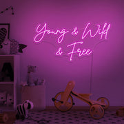 hot pink young wild and free kids neon sign hanging on kids bedroom wall