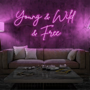 hot pink young and wild and free neon sign hanging  on living room wall