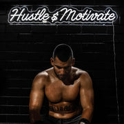 hustle and motivate gym neon sign hanging on black wall above boxer