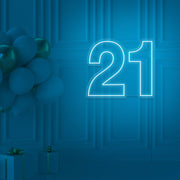 ice blue  21 neon sign hanging on wall with balloons