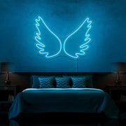 ice blue angel wings neon sign hanging on bedroom wall