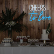 ice blue cheers to love neon sign hanging above dessert table
