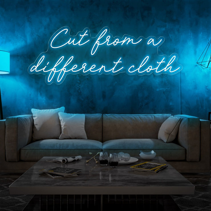 ice blue cut from a different cloth neon sign hanging on living room wall