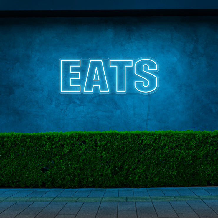 ice blue eats neon sign hanging on outside wall