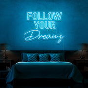 ice blue follow your dreams neon sign hanging on bedroom wall
