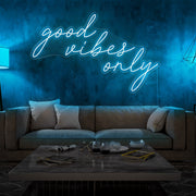 ice blue good vibes only neon sign hanging on living room wall
