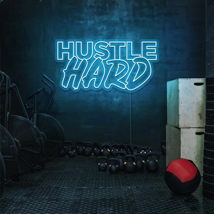 ice blue hustle hard neon sign hanging on gym wall