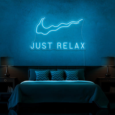 ice blue just relax neon sign hanging on bedroom wall
