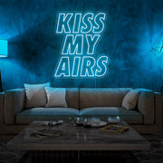 ice blue kiss my airs neon sign hanging on living room wall
