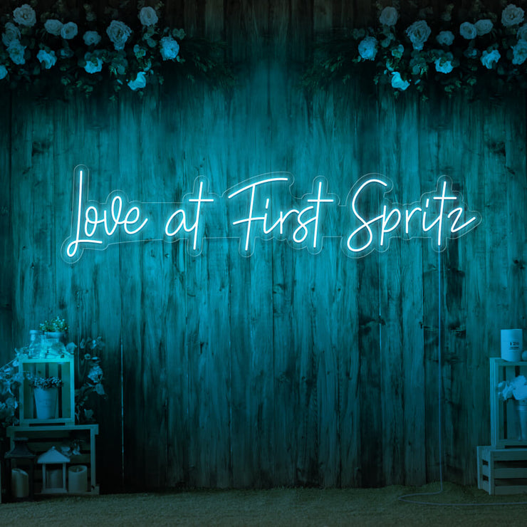 ice blue love at first spritz neon sign hanging on timber wall