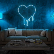 ice blue melting heart neon sign hanging on living room wall