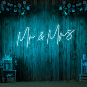 ice blue mr and mrs neon sign hanging on wall with flowers