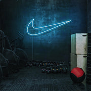 ice blue nike swoosh neon sign hanging on gym wall