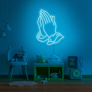 ice blue praying hands neon sign hanging on kids bedroom wall