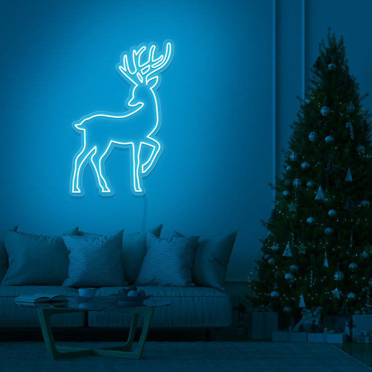 ice blue reindeer neon sign hanging on living room wall next to christmas tree