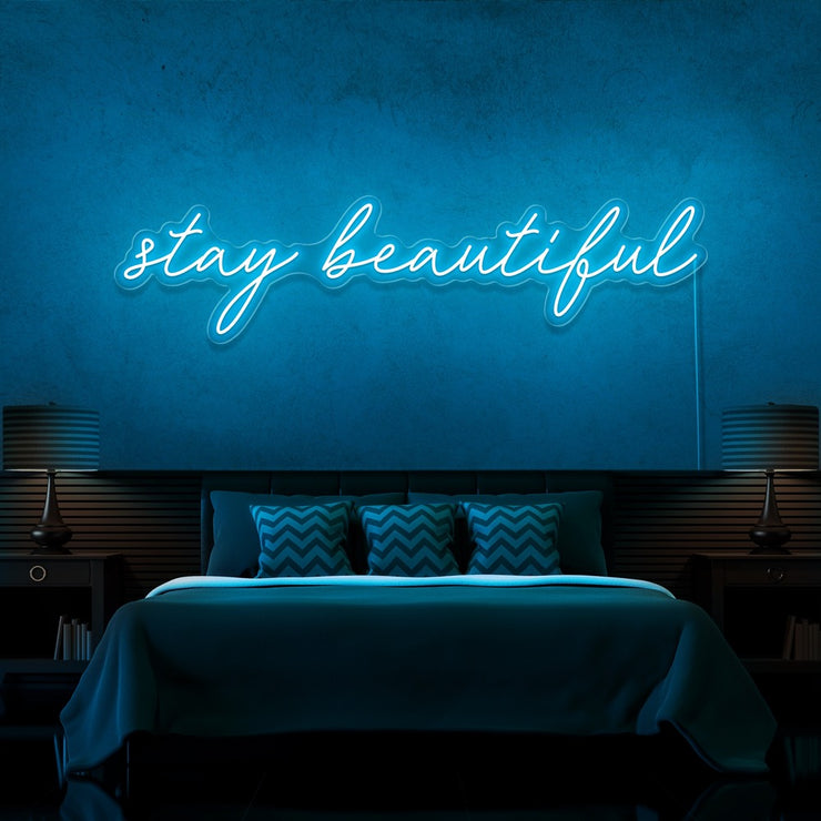 ice blue stay beautiful neon sign hanging on bedroom wall